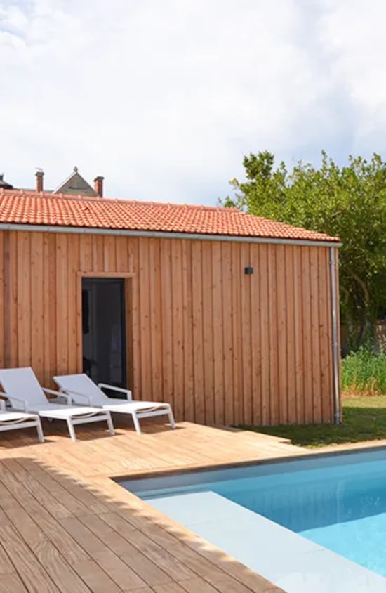 Façade de maison en bord de piscine avec bardage bois couvre-joint Douglas