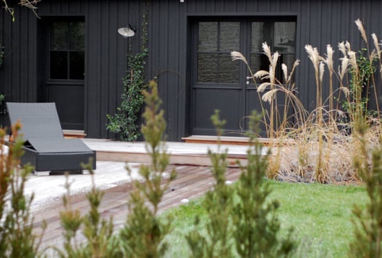 Le bois peint en noir de ce bardage couvre-joint apporte une touche résolument moderne et élégante à cette façade donnant sur le jardin