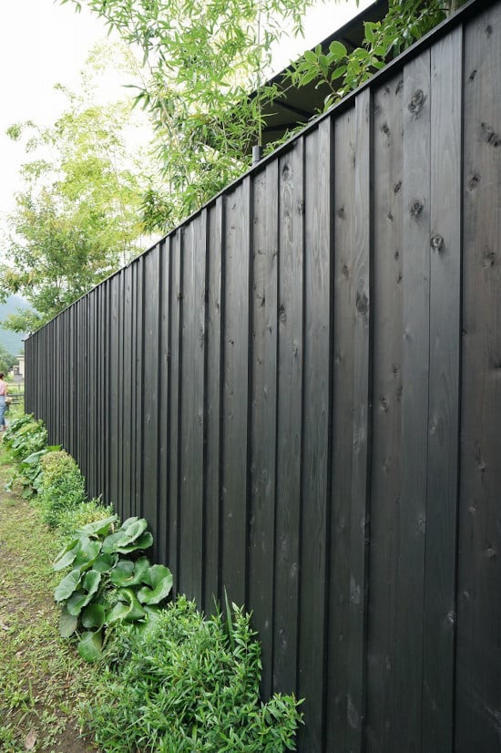 Clôture effet bois brûlé fabriquée avec voliges et bardage couvre-joint en Épicéa traité classe 4