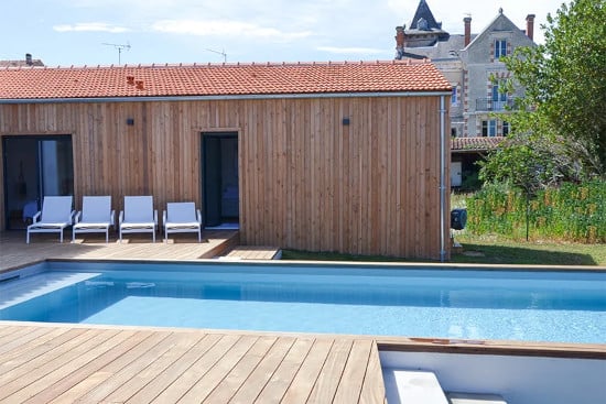 Façade de maison en bord de piscine avec bardage bois couvre-joint Douglas