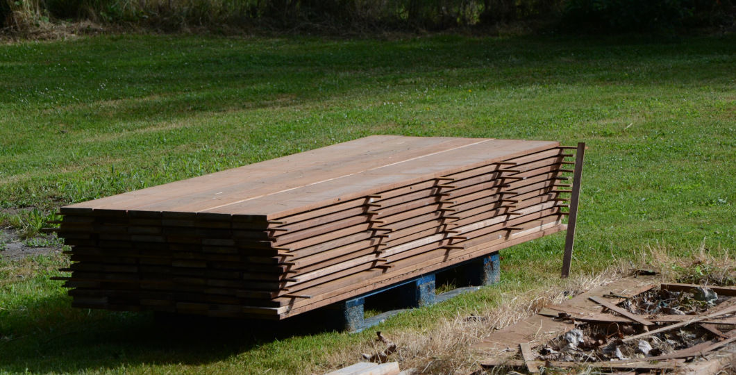Apposition de pièces de bois entre lames de terrasse stockées pour une bonne ventilation